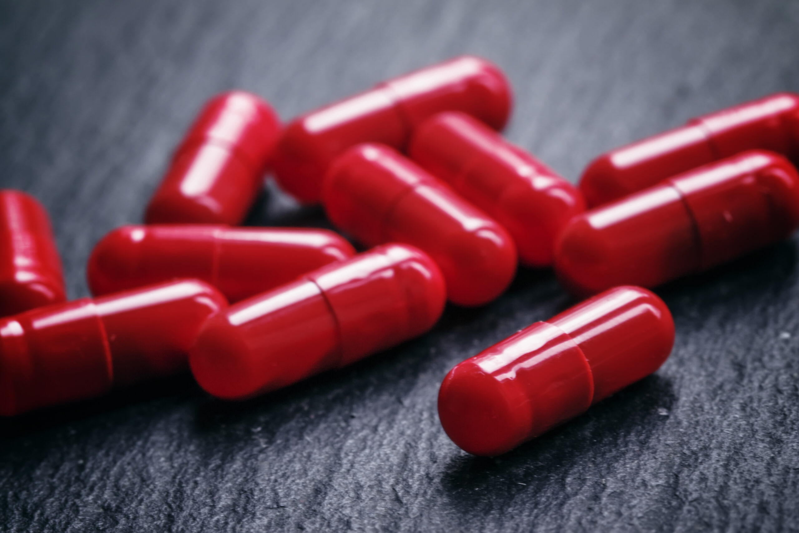 Red pills in capsules of anemia on a black table